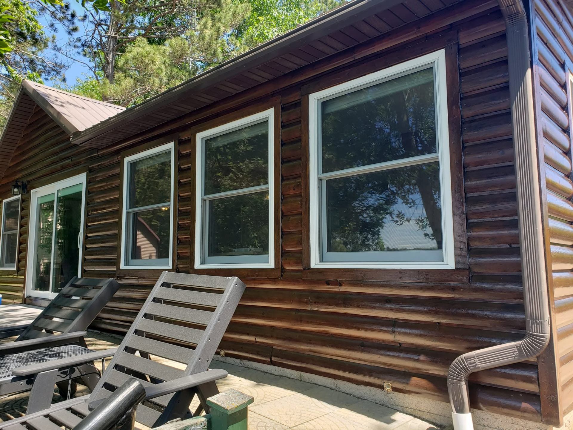 Log cabin with rich dark stain and refinished siding